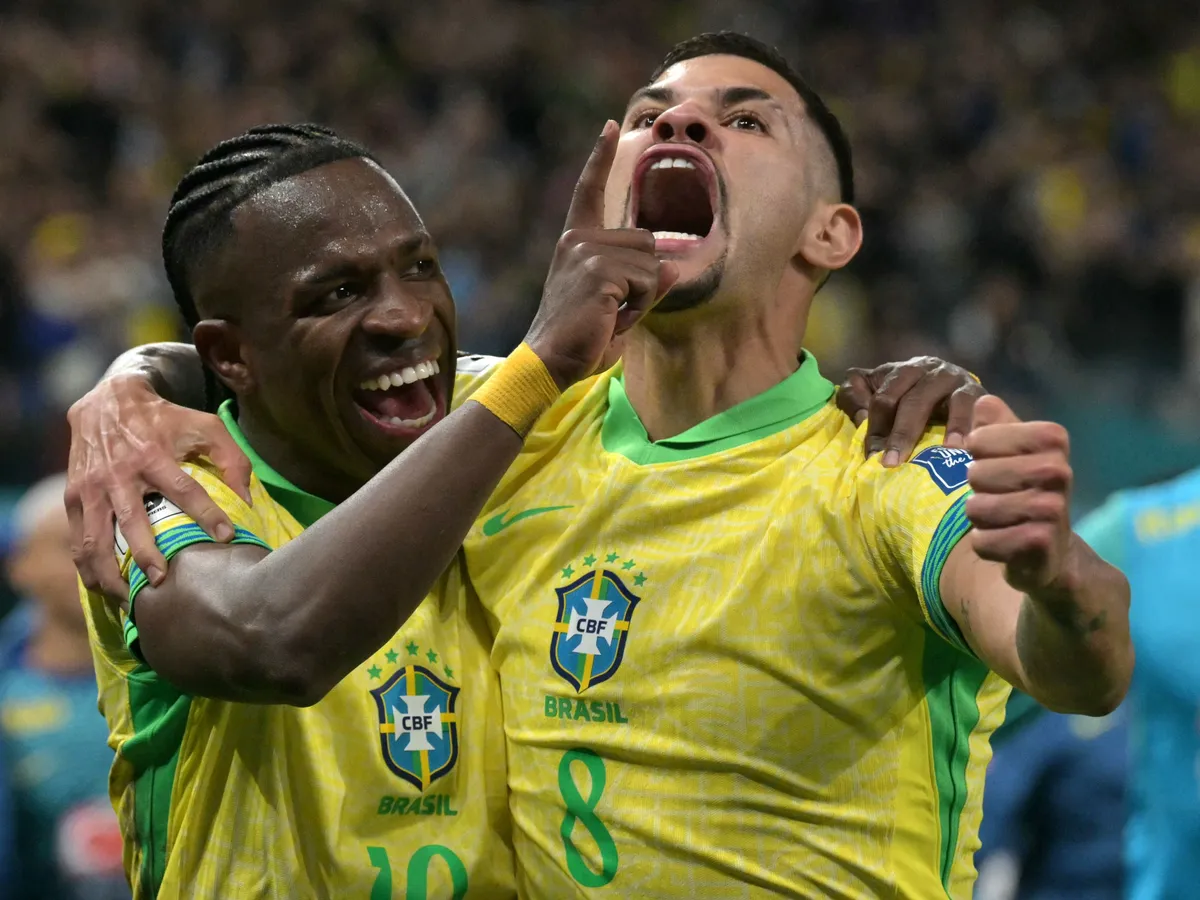 Brazil's forward #10 Vinicius Jr celebrates with teammate midfielder #08 Bruno Guimaraes after scoring his team's first goal during the 2026 FIFA World Cup South American qualifiers football match between Brazil and Paraguay at the Neo Quimica Arena in Sao Paulo, Brazil, on June 10, 2025. (Photo by NELSON ALMEIDA / AFP)
