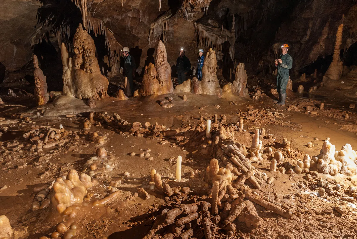 Neandervölgyi építmény a Bruniquel-barlangban, letört állócseppkövekből kirakott kör alakú szerkezet és az azt vizsgáló kutatók