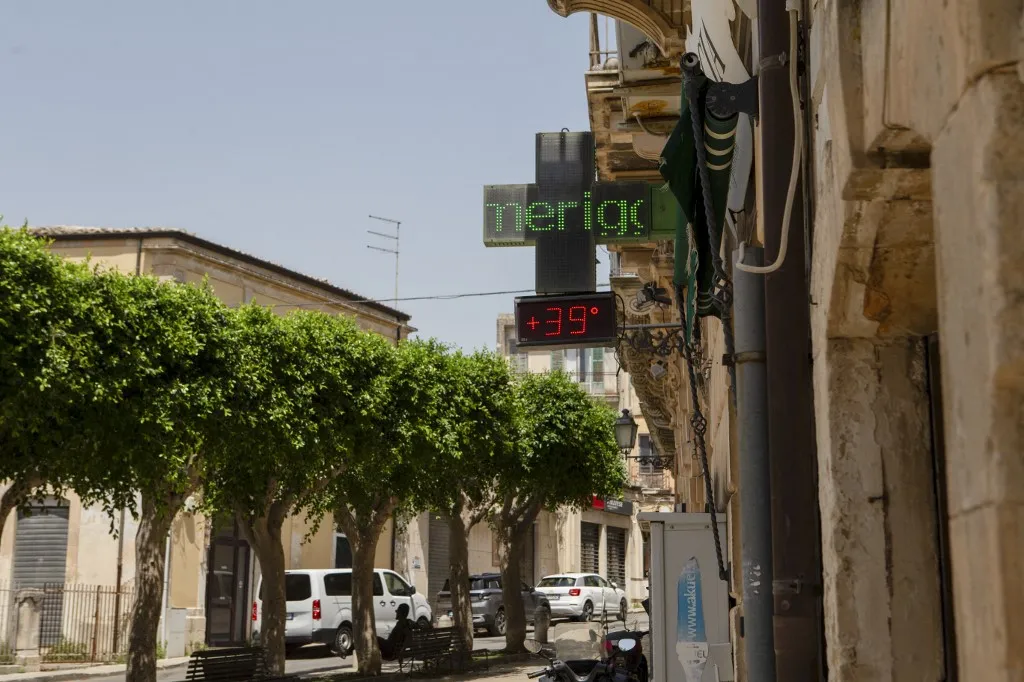A klímaváltozás miatt egyre hosszabb ideig tart a rendkívüli hőség a szicíliai Floridiában Európa hőrekorder településén már az utcára is alig lehet kimenni A pharmacy sign displays a temperature of 39 degrees Celsius during a heatwave in Modica, Sicily, Italy, on July 17, 2026. High temperatures affected parts of southern Italy as a heatwave persisted across the region. (Photo by Elvis Takahashi Mantello / Middle East Images via AFP)