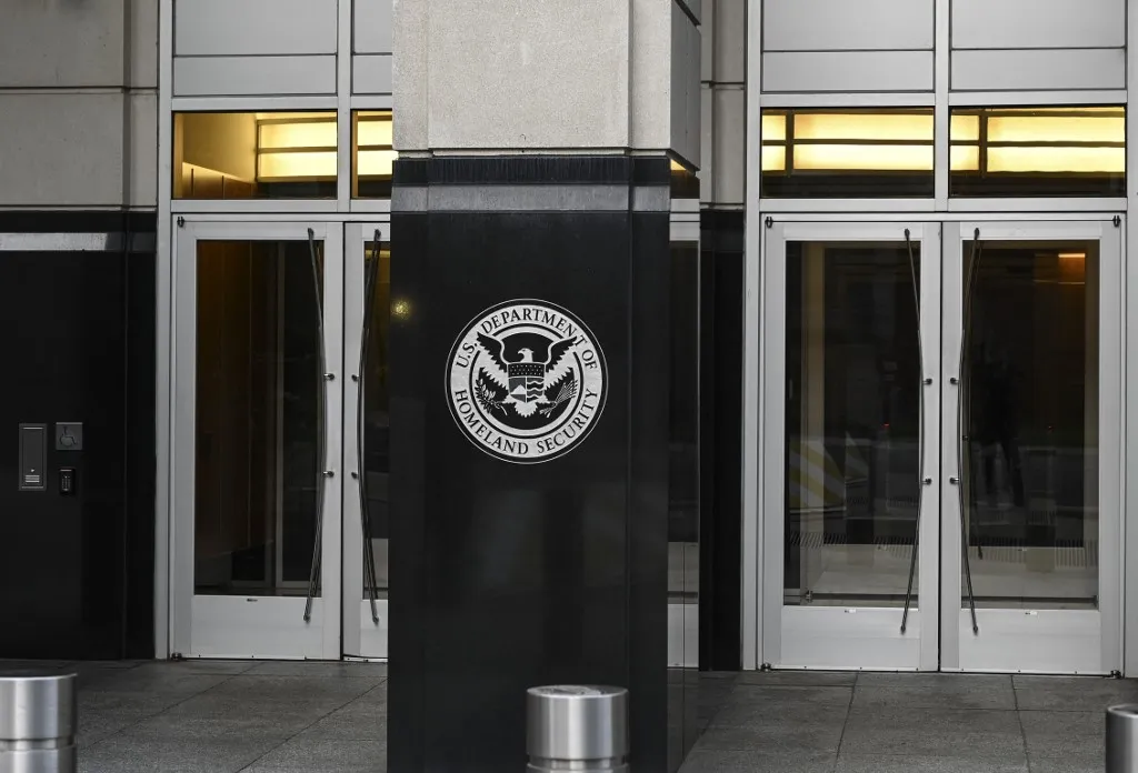Az amerikai Belbiztonsági Minisztérium  táblája a Bevándorlási és Vámügyi Hatóság (ICE) egyik épületének bejáratánál Washingtonban.  Fotó: EVA HAMBACH / AFP