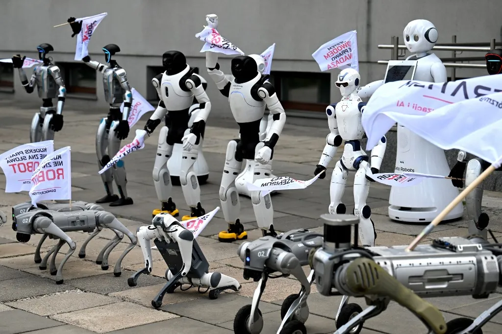 robotok, mesterséges intelligencia, humanoid robotok, automatizáció, Lengyelország, AI Act, munkahelyek, munkaerőpiac, Krzysztof Gawkowski, Grzegorz Kulis Robotok vonultak fel a lengyel Digitális Ügyek Minisztériuma előtt Humanoid and quadruped robots are seen during a demonstration calling for the regulation of artificial intelligence development in Warsaw on September 7, 2026. Waving flags, "chanting" slogans, and marching in circles -- around thirty robots took to the streets to raise awareness for AI regulation in front of the digital affairs ministry on September 7, 2026. (Photo by Sergei GAPON / AFP)