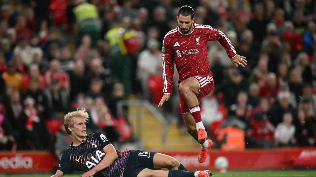 Liverpool's Hungarian midfielder #08 Dominik Szoboszlai jumps over Tottenham Hotspur's Swedish midfielder #15 Lucas Bergvall during the English League Cup third round football match between Liverpool and Tottenham Hotspur at Anfield stadium in Liverpool, north west England on September 15, 2026. (Photo by Paul ELLIS / AFP) / RESTRICTED TO EDITORIAL USE. No use with unauthorized audio, video, data, fixture lists, club/league logos or 'live' services. Online in-match use limited to 120 images. An additional 40 images may be used in extra time. No video emulation. Social media in-match use limited to 120 images. An additional 40 images may be used in extra time. No use in betting publications, games or single club/league/player publications. /