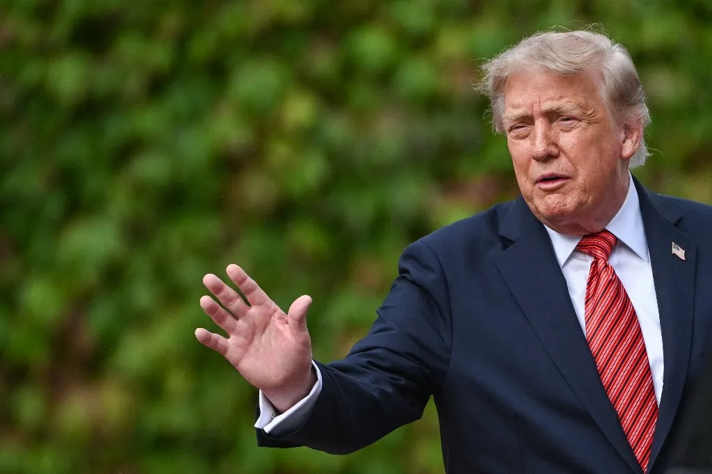 DUBLIN, IRELAND - SEPTEMBER 12: U.S. President Donald Trump extends his hand in a wave goodbye to the press corps as he stands beside his state car at Aras an Uachtarain on September 12, 2026, in Dublin, Ireland. (Photo by Artur Widak/NurPhoto) (Photo by Artur Widak / NurPhoto via AFP)