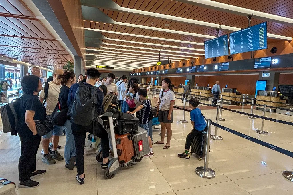 TANGERANG, INDONESIA - SEPTEMBER 6: Passengers check the flight information board after their airline cancelled their flights on safety grounds following volcanic ash from the eruption of Mount Anak Krakatau in Soekarno Hatta Airport, Tangerang, Indonesia on September 06, 2026. Firdaus Wajidi / Anadolu (Photo by Firdaus Wajidi / Anadolu via AFP)