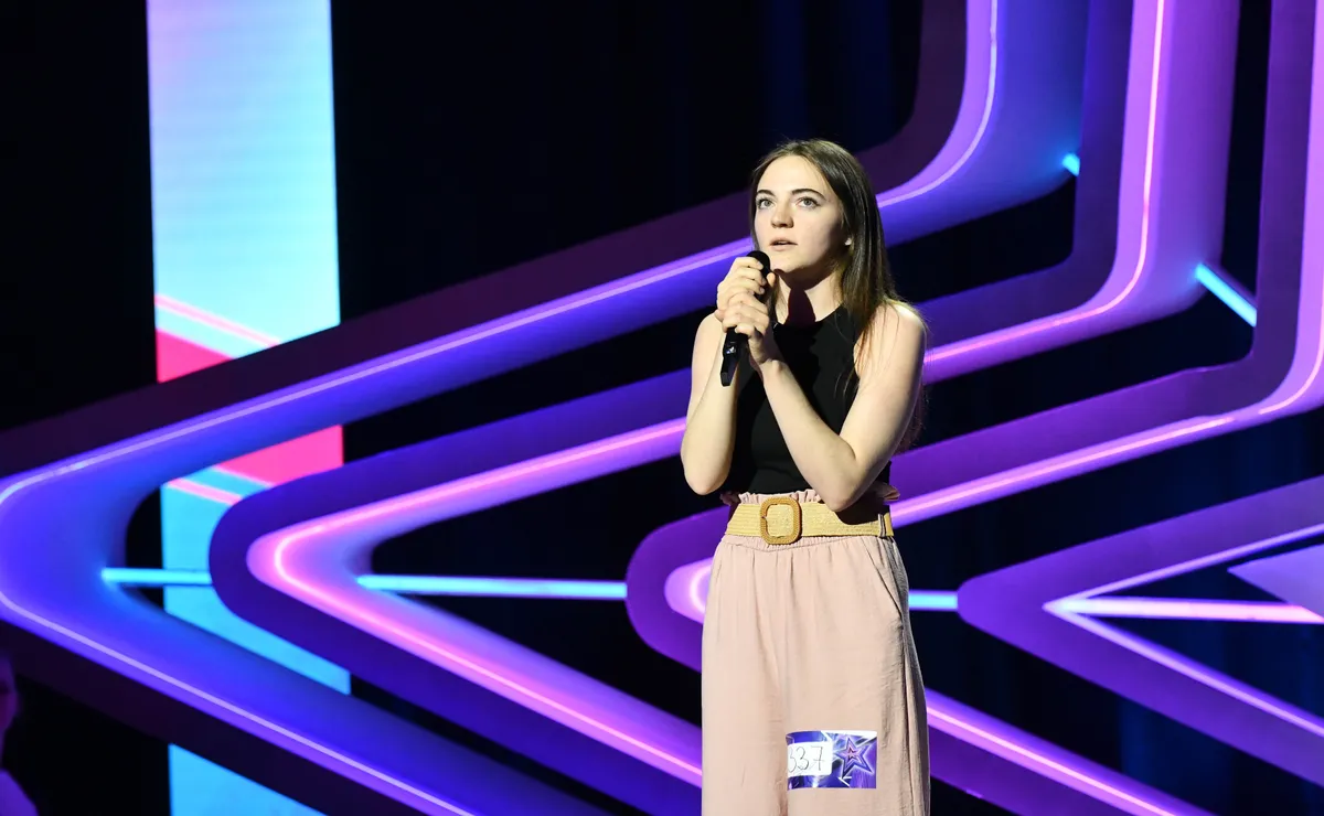 Kovács Júlia mikrofonnal a kezében áll a színpadon.