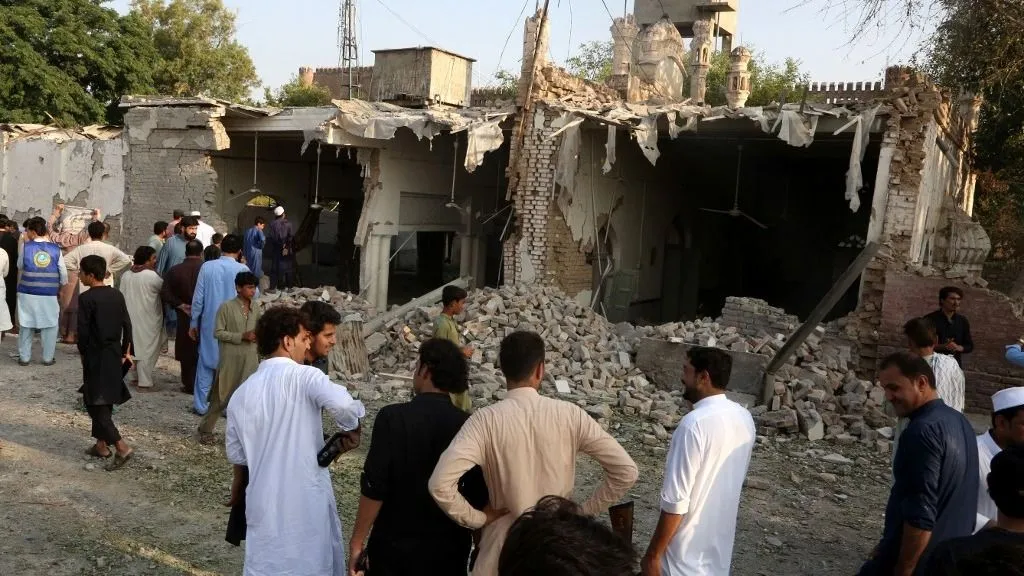 pakisztáni terrortámadás, KHYBER PAKHTUNKWA, PAKISTAN - SEPTEMBER 18: People gather around a damaged mosque following a suicide bombing targeting a police compound in Kohat district of Khyber Pakhtunkhwa province, Pakistan, on September 18, 2026. At least 16 people, including 11 civilians and five police officers, were killed and over 50 others wounded in a suspected suicide bombing targeting a police compound in northwestern Pakistan during Friday congregational prayers, officials said. The casualties occurred when an explosives-laden vehicle rammed into the Old Police Lines gate in Kohat district of Khyber Pakhtunkhwa province, a senior police official said, according to local broadcaster Geo News. Kohat District Hospital's top official, Tahir Ali Shah, confirmed that 15 bodies were brought to the health facility, besides wounded people. Khyber Pakhtunkhwa police identified the deceased as 11 civilians and five police officers. Police said six 'terrorists,' including a suicide bomber, were also killed in the explosion. Hussain Ali / Anadolu (Photo by Hussain Ali / Anadolu via AFP)