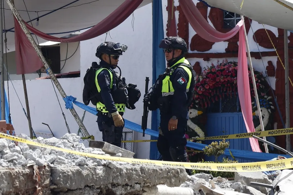 Mexican State Police officers inspect the site of a fireworks blast during a patronal festival in Santa Maria Canchesda, Mexico state, Mexico on September 6, 2026. A fireworks explosion at a church while hundreds of people were celebrating a patron saint's festival in Mexico killed at least 10 people and left more than 60 injured, authorities reported September 6, 2026. (Photo by Ramses MERCADO / AFP)