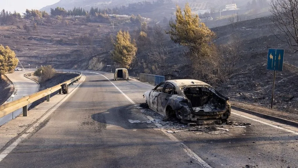 tűz, This photograph shows burnt cars on a road after a wildfire near the town Omis, some 30 kilometres south of Split, on August 14, 2026. Croatian firefighters battled overnight with "one of the worst" wildfires in the country's history, authorities said on August 14, 2026, as flames engulfed homes and injured 19 people on the coast. Hundreds were forced to evacuate from villages near the town of Omis as the fire, which had begun in a settlement of Lokva Rogoznica, ripped through the surrounding hills. (Photo by MIROSLAV LELAS / AFP)