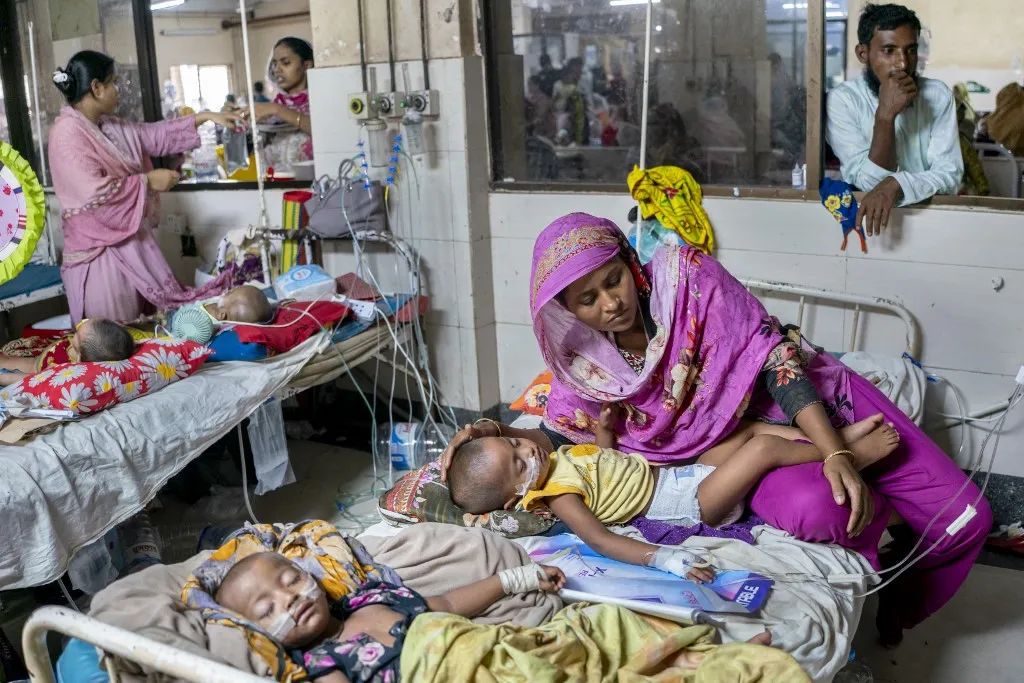 kanyarójárvány, kanyaró tünetei, kanyaró elleni oltás, bangladesi kanyarójárvány, gyermekek oltása, fertőző betegségek, UNICEF, WHO, védőoltás, járvány A kanyaró terjedése egyre nagyobb terhet ró a bangladesi kórházakra A mother rests on a hospital bed beside her child receiving IV fluids, while another child sleeps nearby at Chattogram Medical College Hospital (CMCH) in Chattogram, Bangladesh, on September 16, 2026. The hospital is crowded, reflecting the current measles epidemic in southern Bangladesh. (Photo by Zakir Hossain/NurPhoto) (Photo by Zakir Hossain / NurPhoto via AFP)
