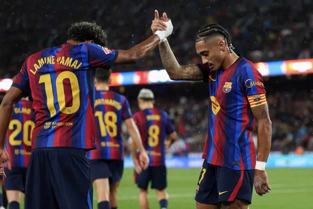 Barcelona's Brazilian forward #11 Raphinha celebrates scoring his team's second goal from the penalty spot with Barcelona's Spanish forward #10 Lamine Yamal during the Spanish league football match between FC Barcelona and Racing Santander at the Camp Nou stadium in Barcelona on September 16, 2026. (Photo by Lluis GENE / AFP)