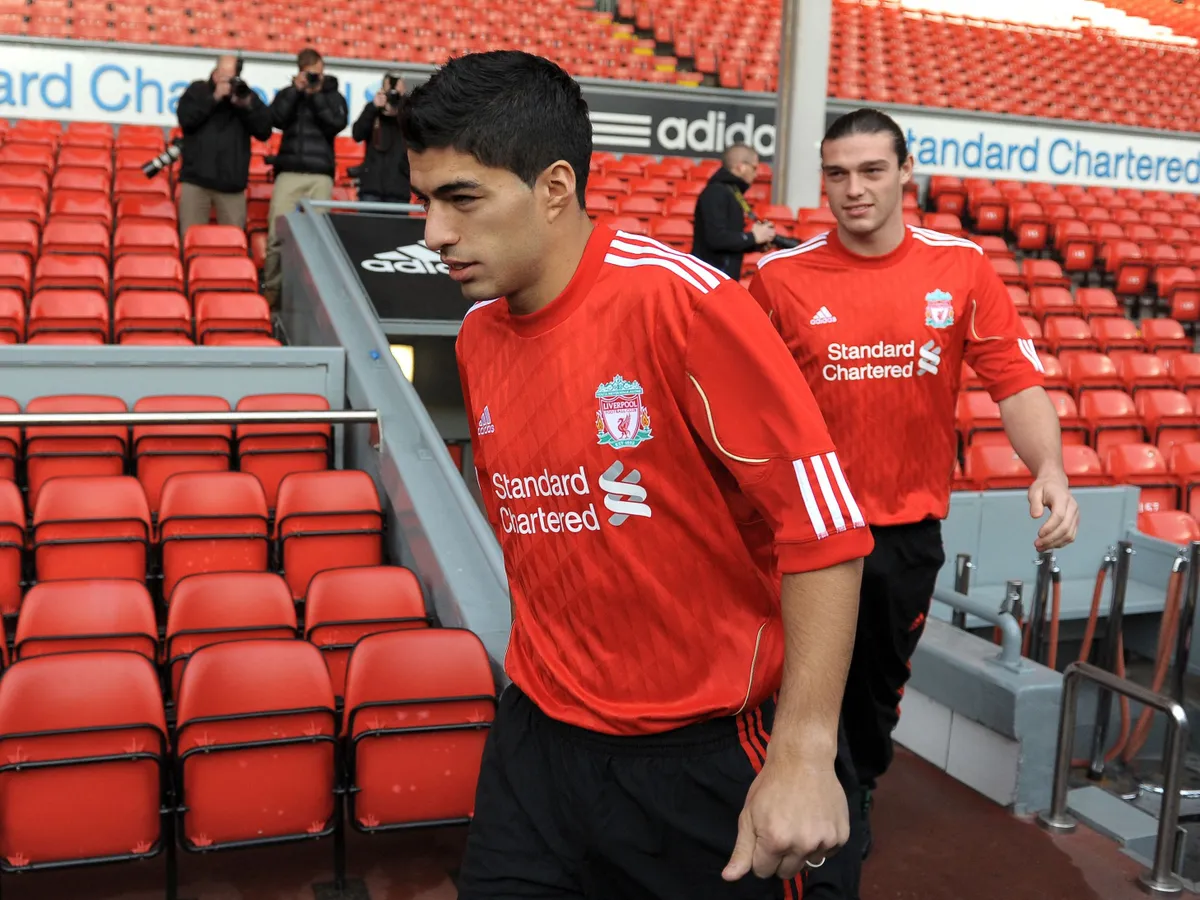 Liverpool's new signings Uruguayan striker Luis Suarez (L) and English striker Andy Carroll arrive for a photocall at Anfield, Liverpool, northwest England, on February 3, 2011. Liverpool manager Kenny Dalglish promised more to come from Luis Suarez after revealing the Uruguay striker had not even trained with his new side before marking his Premier League debut with a goal. Suarez ensured Liverpool supporters, dejected by the loss of Fernando Torres to Chelsea on Monday, had a new hero after coming off the substitutes' bench to score in the 2-0 victory over Stoke at Anfield on Wednesday. AFP PHOTO/ ANDREW YATES  RESTRICTED TO EDITORIAL USE Additional licence required for any commercial/promotional use or use on TV or internet (except identical online version of newspaper) of Premier League/Football League photos. Tel DataCo +44 207 2981656. Do not alter/modify photo   . (Photo by ANDREW YATES / AFP)
