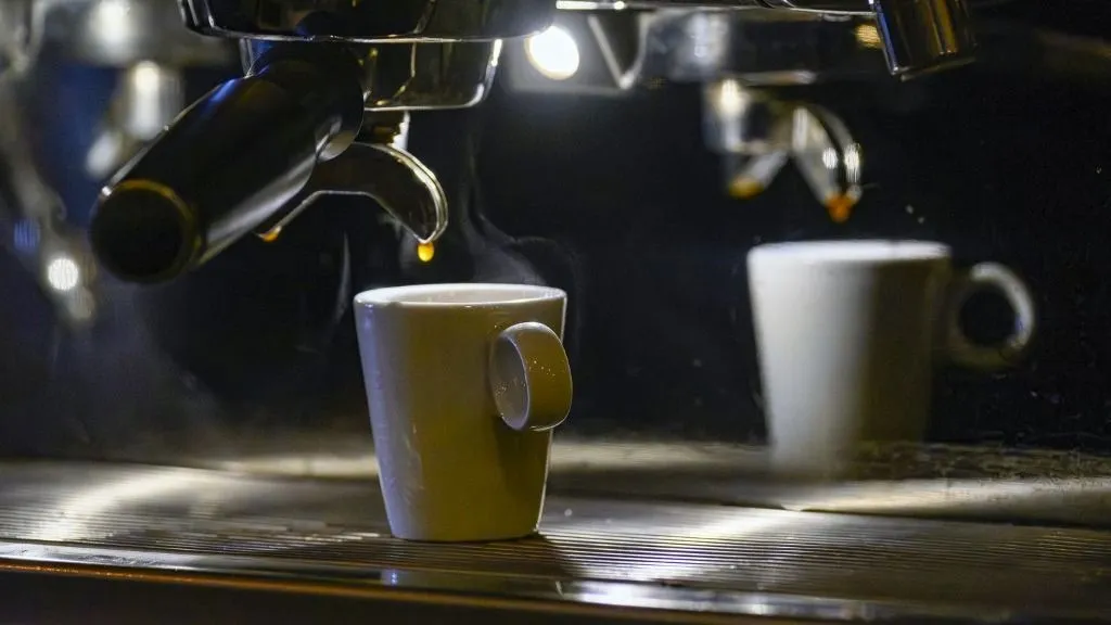 kávé, Under the warm light of a bistro counter, a coffee cup receives a shot of espresso in front of a chrome machine in operation in the early morning in Paris on October 22, 2025.Sous la lumiere chaude d un comptoir de bistrot, une tasse a cafe recoit une dose d expresso devant une machine chromee en fonctionnement au petit matin a Paris le 22 octobre 2025. (Photo by Eric Beracassat / Hans Lucas via AFP)
