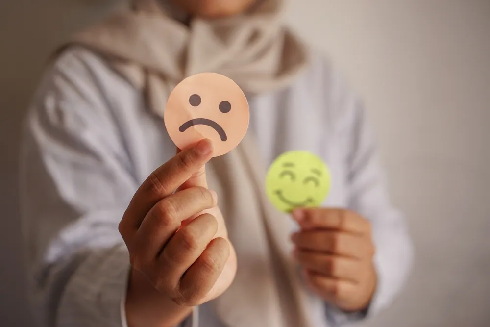 A bipoláris zavar fel- és lehangolt epizódja, smiley-val a nő kezében