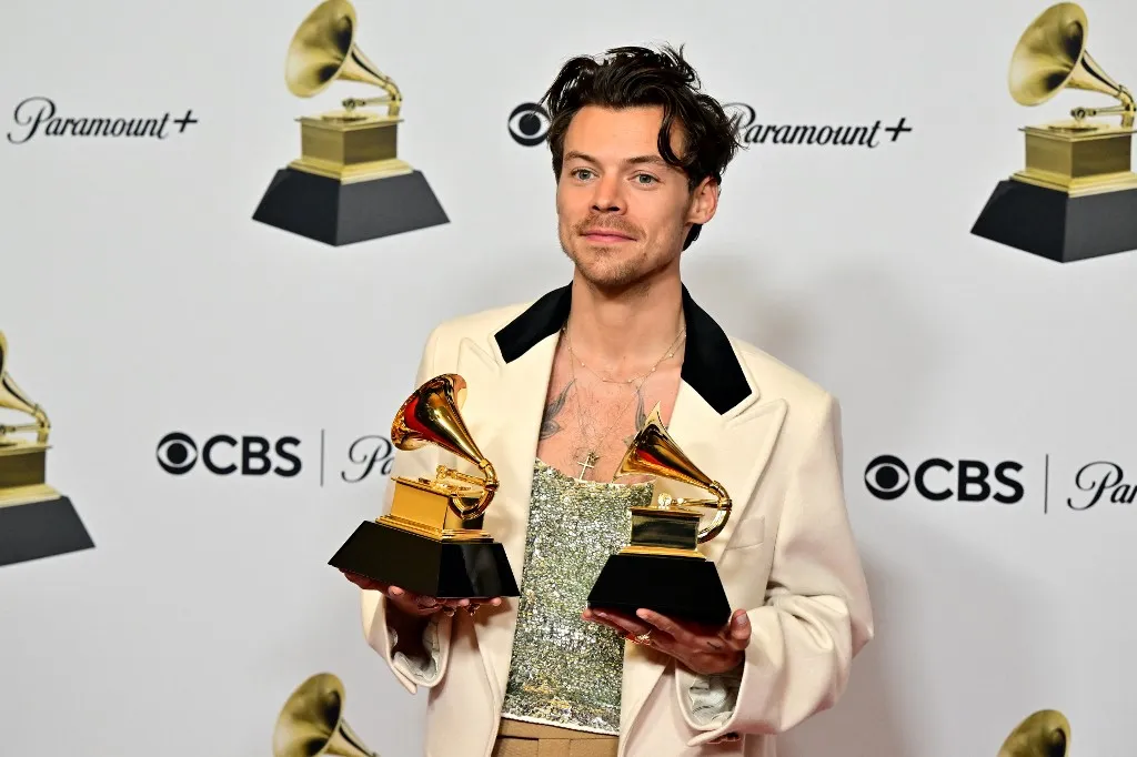 English singer-songwriter Harry Styles poses with the awards for Album Of The Year for "Harrys House" and Best Pop Vocal Album for "Harrys House" in the press room during the 65th Annual Grammy Awards at the Crypto.com Arena in Los Angeles on February 5, 2023. (Photo by Frederic J. Brown / AFP)
