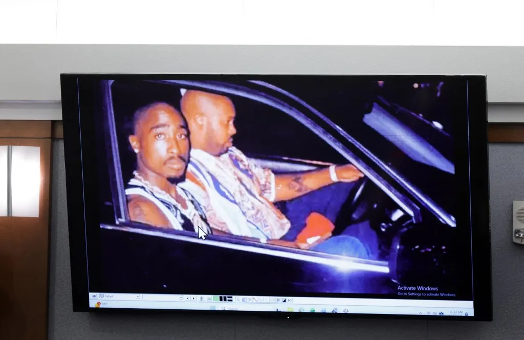 A 1996 photo of rapper Tupac Shakur (L) and Marion Suge Knight is  displayed during the Duane Davis murder trial, related to the 1996 killing of the rapper, at Clark County District Court at the Regional Justice Center in Las Vegas, Nevada, on August 17, 2026. The trial of the former gang leader accused of orchestrating the murder of rapper Tupac Shakur began on August 10, 30 years after one of America's most high-profile unresolved killings. The proceedings, expected to last a month, will likely not make clear who fired the shots that killed the California hip-hop legend on the night of September 7, 1996, while he was in Las Vegas to see a Mike Tyson boxing match. (Photo by STEVE MARCUS / POOL / AFP)