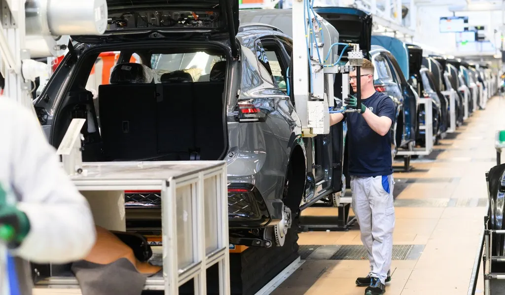 PRODUCTION - 07 March 2025, Lower Saxony, Wolfsburg: An employee installs seats in a new Volkswagen Tayron at the VW main plant. Photo: Julian Stratenschulte/dpa (Photo by JULIAN STRATENSCHULTE / dpa Picture-Alliance via AFP)