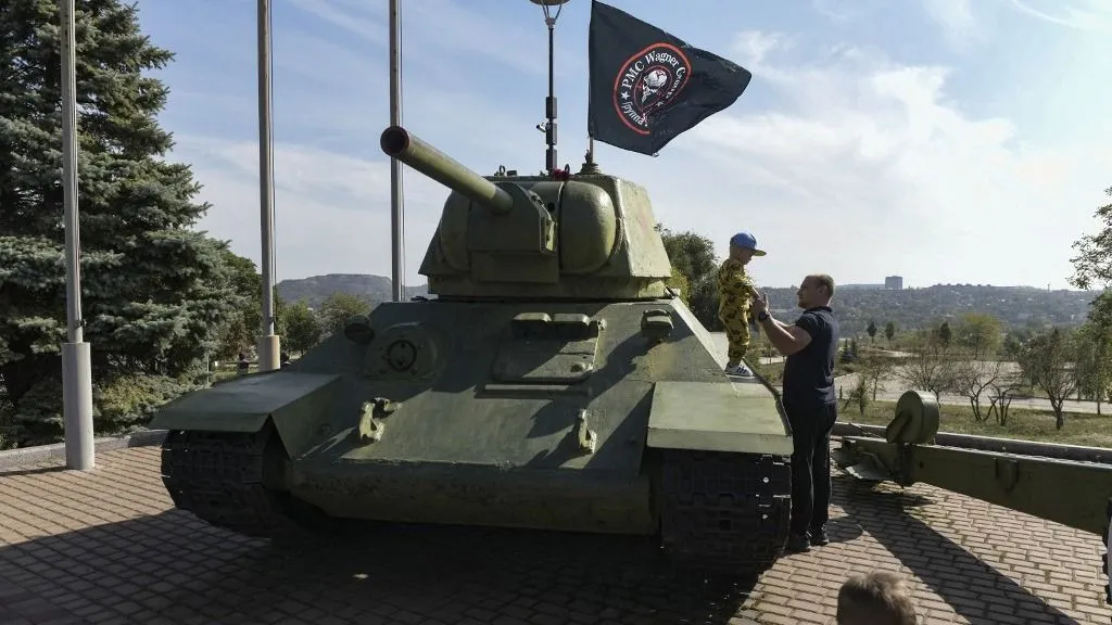 Jevgenyij Prigozsin korábban alkut ajánlhatott Ukrajnának. Erről Kirillo Budanov, az Ukrán Elnöki Hivatal vezetője beszélt, aki korábban a védelmi minisztérium katonai hírszerzését vezette (A képen egy férfi segít egy fiúnak megvizsgálni egy régi harckocsit, amelyet a Wagner-csoport zászlajával díszítettek fel a donyecki Lenin Komszomol parkban. A fotó 2023. október 1-jén készült, amikor Jevgenyij Prigozsin halálának 40. napjáról emlékeztek meg az ortodox hagyomány szerint)