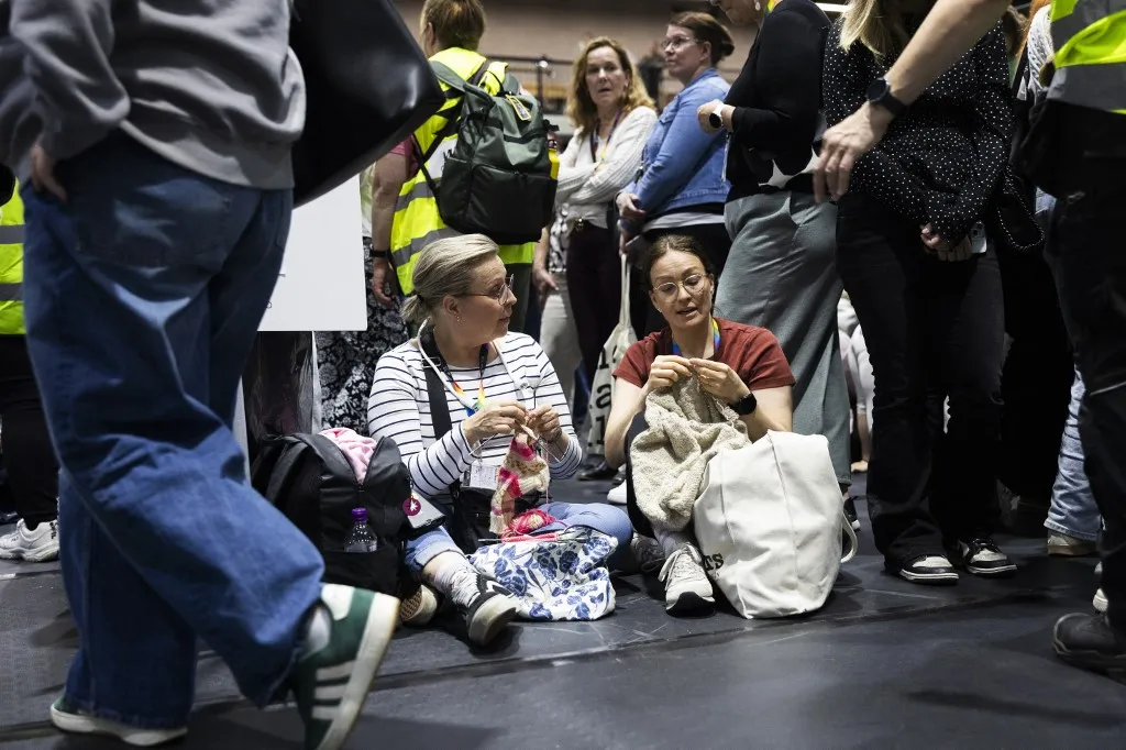 Participants knit inside a shelter during the Shelter 2026 civil emergency and defence exercise in Kuopio, Finland, on September 2, 2026. The civil emergency and defence exercise is designed to test the protection of large numbers of people and the emergency response to major disruptions, while strengthening coordination between authorities and regional partners, as well as command structures, decision-making, situational awareness and communications when day-to-day societal functions are disrupted. (Photo by Matias Honkamaa / Lehtikuva / AFP) / Finland OUT