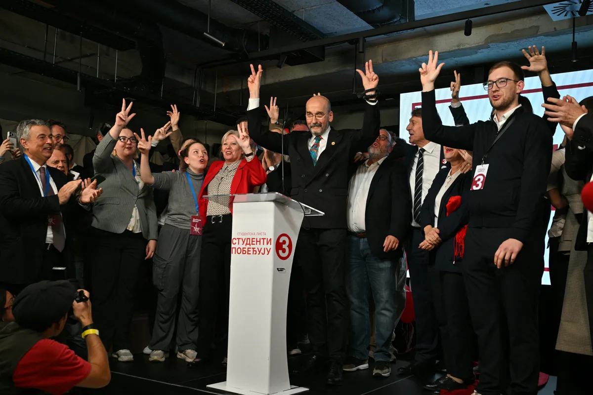 Szerbia, választás, Diáklista, Egyetemista Lista, Studentska lista 2026. október 25.  Radomir Saicic (C), a chemistry professor and candidate on the student-backed electoral list, celebrates the Students List victory in the Serbian parliamentary elections on stage with other candidates and supporters at their headquarters in Belgrade on October 25, 2026. The vote saw the hightest voter turnout in over 30 years according to the election commission and is the culmination of nearly two years of student-led protests sparked by the 2024 collapse of a canopy at Novi Sad railway station that killed 16 people, a tragedy widely blamed on corruption. (Photo by Andrej ISAKOVIC / AFP)