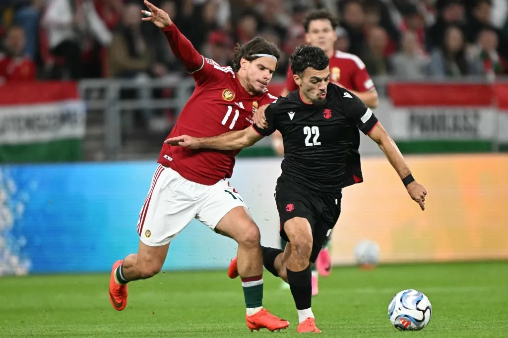 Hungary's midfielder #11 Milos Kerkez (L) and Georgia's forward #22 Georges Mikautadze vie for the ball during the UEFA Nations League Group B2 football match between Hungary and Georgia at the Puskas Arena in Budapest, Hungary on October 2, 2026. (Photo by Attila KISBENEDEK / AFP)