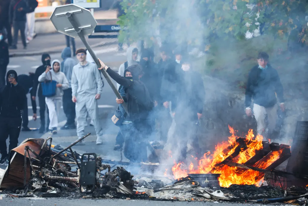 Egy tüntető stoptáblát dob ​​a tűzbe, miközben a tiltakozó diákok blokádot hajtottak végre a brest-i Kerichen középiskola közelében, Nyugat-Franciaországban, 2026. október 2-án. Szeptember vége óta a diákok tüntetéseket szerveznek iskolák előtt a sérelmek