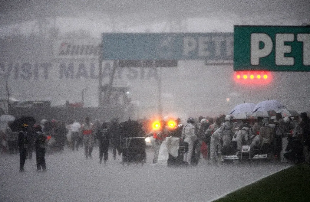 The race is stopped as heavy rain falls during the Malaysian Grand Prix in Sepang on April 5, 2009. Jenson Button won a chaotic Malaysian Grand Prix for a second straight victory after the race was abandoned on 32 laps when a ferocious storm lashed the Sepang circuit. AFP PHOTO / NICOLAS ASFOURI (Photo by NICOLAS ASFOURI / AFP)