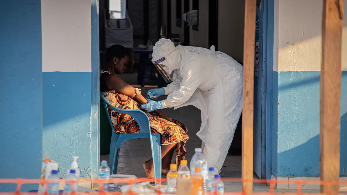 Az ebola már két ember életét követelte Kenyában. Hét fertőzöttet kezelnek, köztük egészségügyi dolgozókat., A healthcare worker takes samples from a patient suffering from Ebola virus disease at the Ebola Treatment Center of the Center Médical Évangélique (CME), in Bunia, Ituri, in the east of the Democratic Republic of Congo on June 23, 2026. (Photo by Benediction MURHABAZI / AFP)