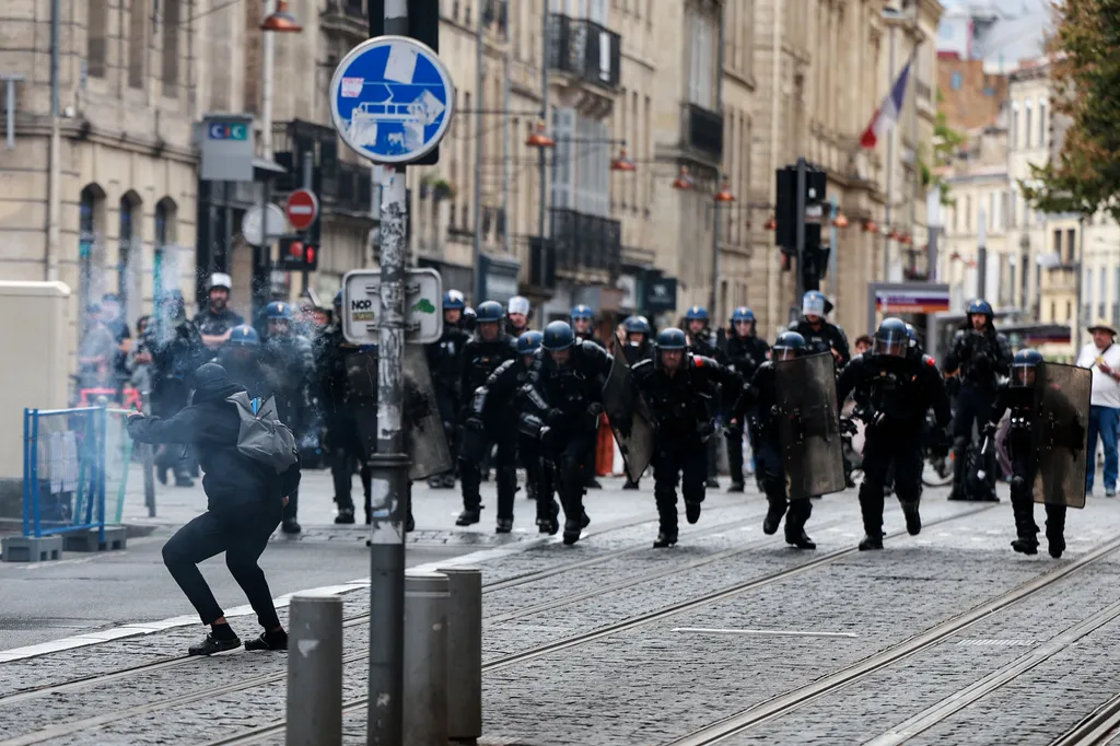 Francia csendőrök rohannak egy középiskolás diák felé, aki tűzijáték-vetőt szegezett rájuk, miközben a tiltakozó diákok Bordeaux utcáin tüntetnek, Délnyugat-Franciaországban, 2026. október 1-jén. Szeptember vége óta a diákok tüntetéseket szerveznek iskolá