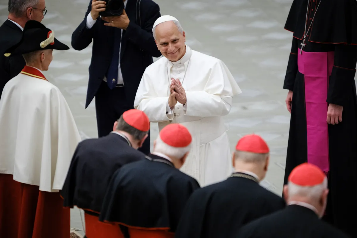 Pope Leo XIV greets clergy gathered inside the Paul VI Hall in Vatican City on May 6, 2026. The annual ceremony marks the anniversary of the May 6, 1527 Sack of Rome, when 147 Swiss Guards died defending Pope Clement VII. Twenty-eight new recruits took the oath of allegiance in the presence of Pope Leo XIV in 2026. (Photo by Andrea Calandra / Middle East Images via AFP), XIV. Leó pápa
